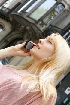 A young adult woman talking on the phone.