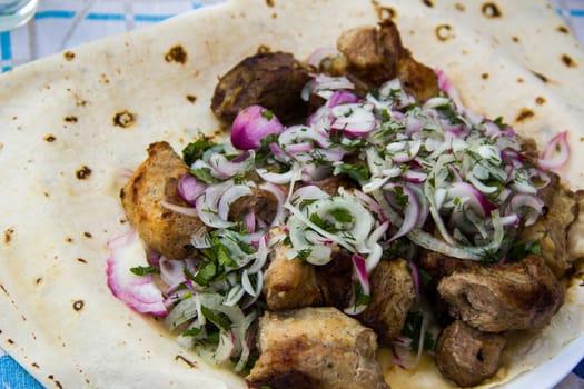 skewers with onion and herbs on flatbread pita