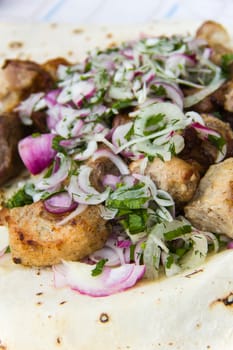 skewers with onion and herbs on flatbread pita