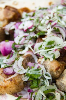 skewers with onion and herbs on flatbread pita