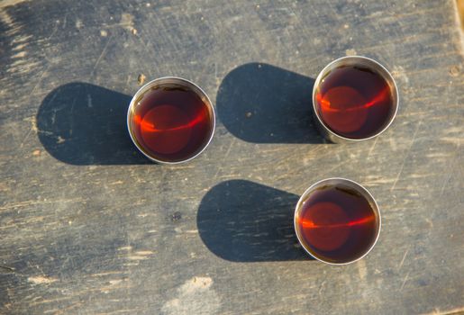 three glasses of alcohol on a wooden board