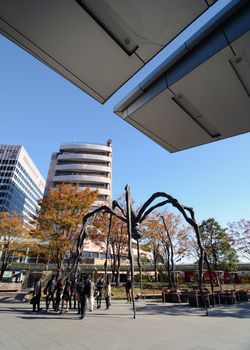TOKYO, JAPAN - NOVEMBER 23, 2013: People visit the spider sculpture outside of Mori Tower in Roppongi Hills on November 23, 2013 in Tokyo Japan.
