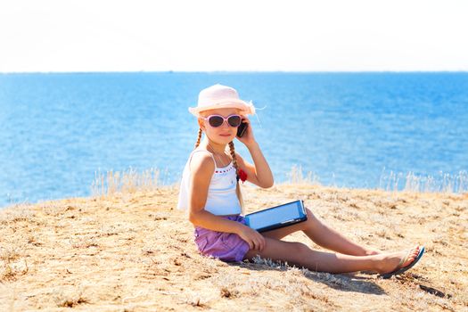 girl on the beach with laptop and phone
