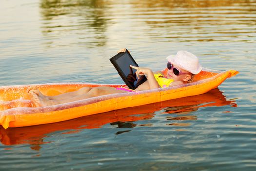 girl on the swimming mattress with laptop