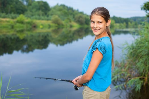 Summer vacation - Photo of cute girl fishing on the river.