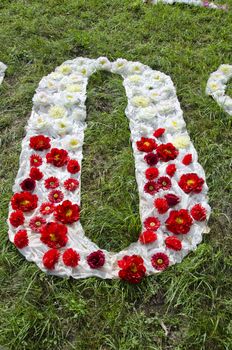 beautiful cloth and flower alphabet letter O on grass in park