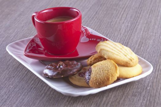 Coffee in red cup with different kind of biscuits