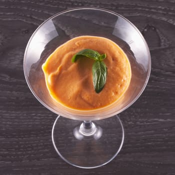 Gazpacho in a glass cup over wooden table