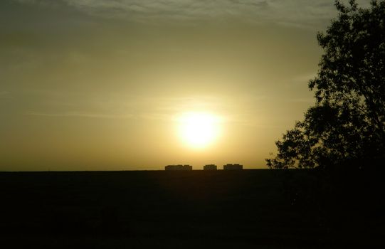 sunset over the border between city and nature