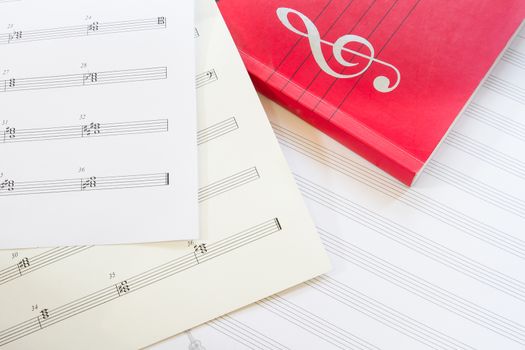 Sheet music and music book with g clef