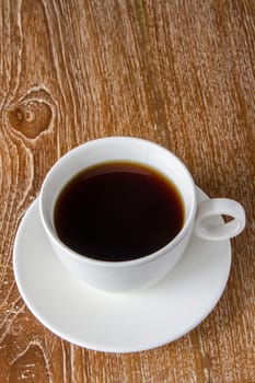 White cup of coffee on wooden table