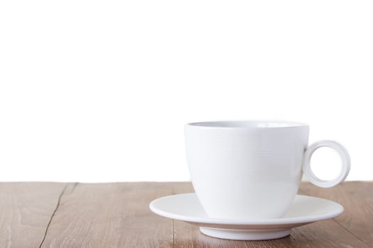 White cup of coffee on wooden table with copyspace area