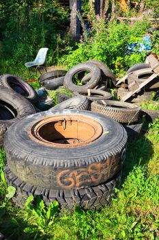 Heap of used tires on messy junkyard