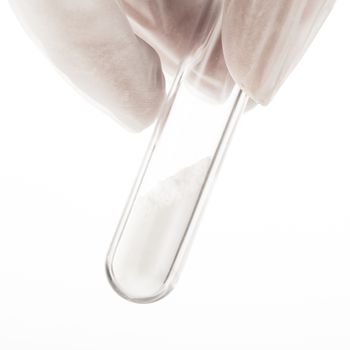 Close up of white powder in test tube being held by fingers