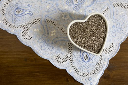 Healthy dark chia seeds in heart container