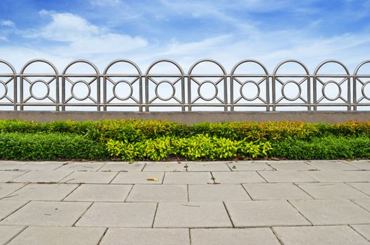 shrubs and stainless steel fence on blue sky background