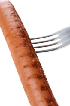 a delicious sausage on a fork over white