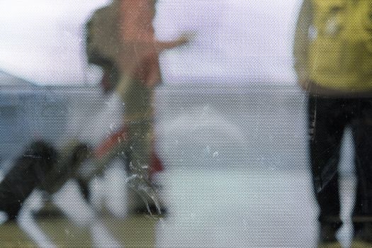 Cropped out of focus shot of passengers caring luggages in airport corridor