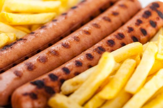 three delicious wurstel on a white plate with french fries