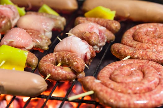 different types of meat cooking outside on a barbecue