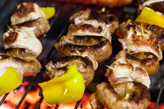 different types of meat cooking outside on a barbecue