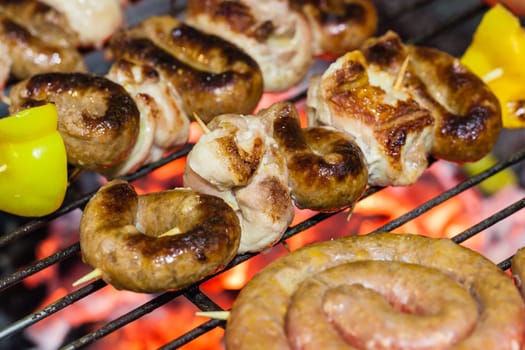 different types of meat cooking outside on a barbecue