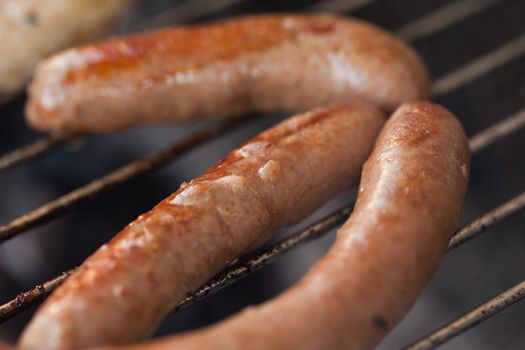 Several type of meats being cooked on a barbecue