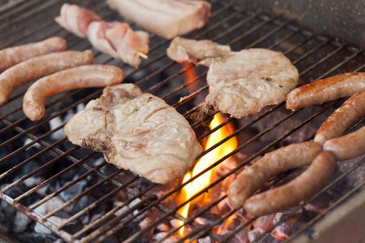 Several type of meats being cooked on a barbecue