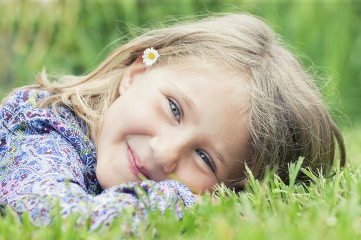 Little adorable girl lying on grass smiling