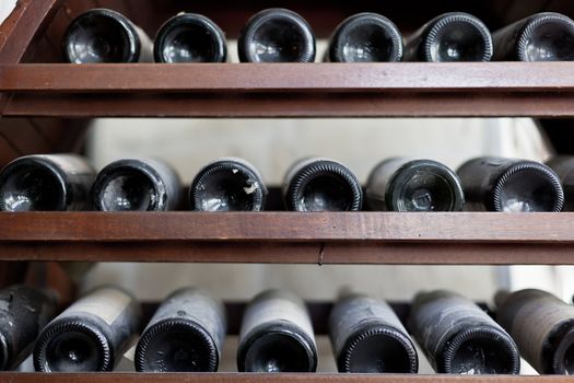 some very old and dusty wine bottles in a wine cellar