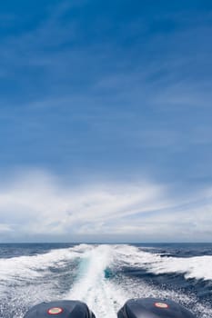 Boat trails under blue sky