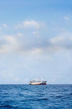 Rusty Commercial Ship sailing on a blue sea