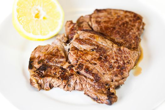 a Juicy Steak in a white plate over a white background