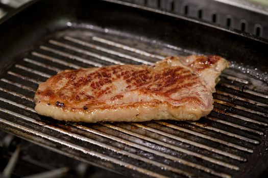 a steak cooking on a dirty pan