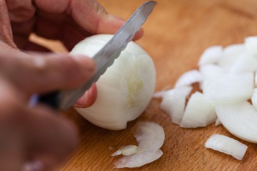 cutting onions on a wooden chopping board