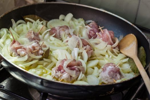 Cooking chops and onions in a big frying pan