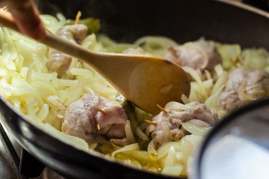 Cooking chops and onions in a big frying pan