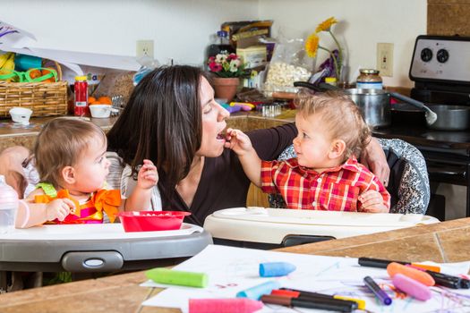 Baby feeds his mother cereal at breakfast