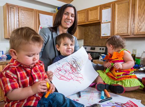 Mother and child in kitchen pose with a drawing