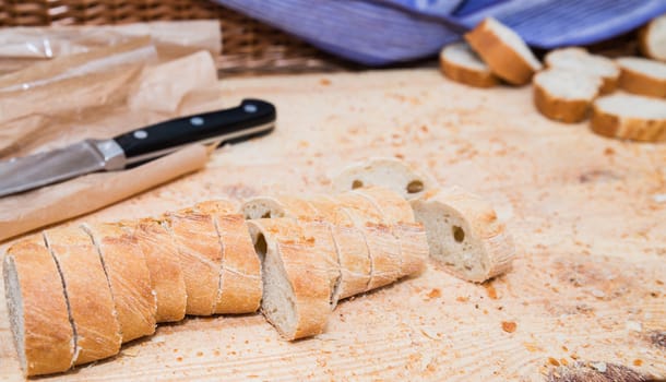 Sliced bread on wood texture with knife and crumbs