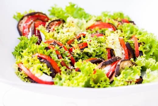 Colourfull green salad on white plate close-up