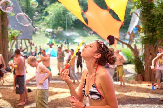 OZORA, HUNGARY - AUGUST 01: Girl blowing bubles on Ozora Festival, one of the greatest psychedelic music gathering in Euorpe. Ozora, Hungary, Europe August 01, 2014.