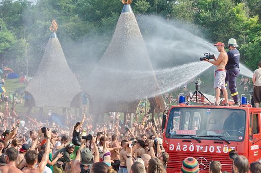 OZORA, HUNGARY - AUGUST 01: Fire department spray water on crowd on Ozora Festival, one of the greatest psychedelic music gathering in Euorpe. Ozora, Hungary, Europe August 01, 2014.