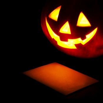 Halloween pumpkin lantern and post card isolated on black background