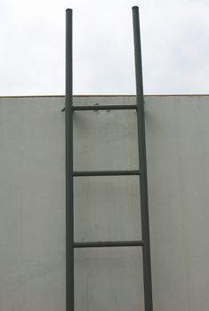 Ladder leaning on wall for climbing up on the rooftop.                              