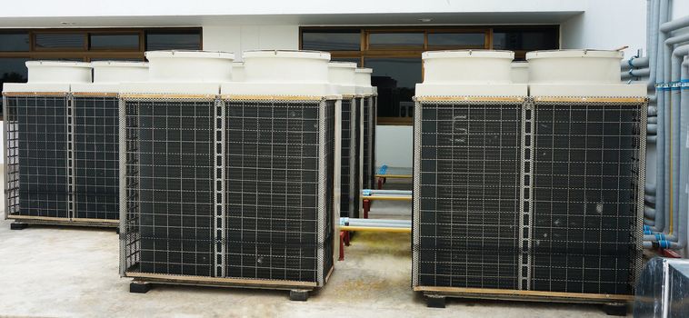 Several large air conditioning equipment arranged on the rooftop of the building .                              