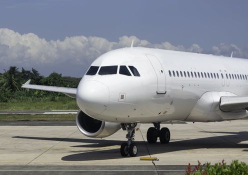 Commercial airplane on tarmac waiting to be serviced by ground crew