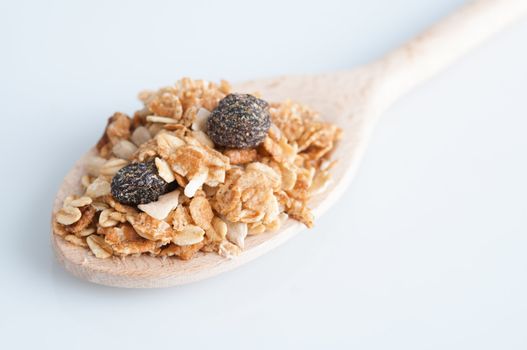 Muesli morning breakfast on wooden spoon, plain background