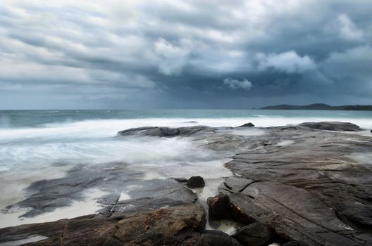 sea landscape with bad weather, rocks and rainy sky