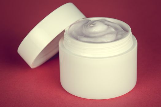 Beauty face cream container on pink background
